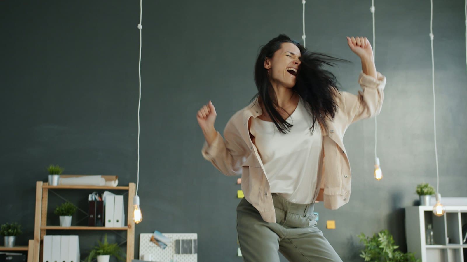 A woman dancing joyfully with her arms raised
