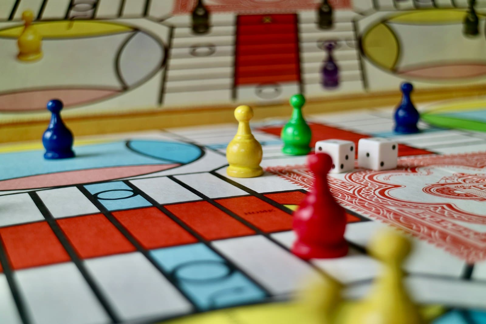 Game pieces and dice mid-game on a ludo board