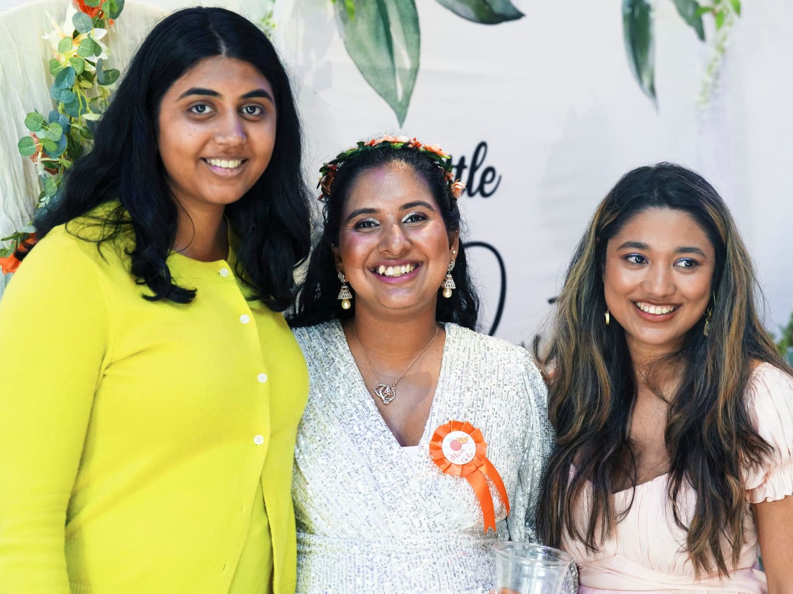 Three friends smiling together at an event